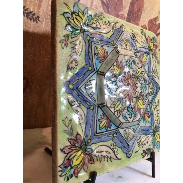 Exceptional Persian tile all hand-painted and glazed, with beautiful colors of geometric and floral motifs painted on a...
