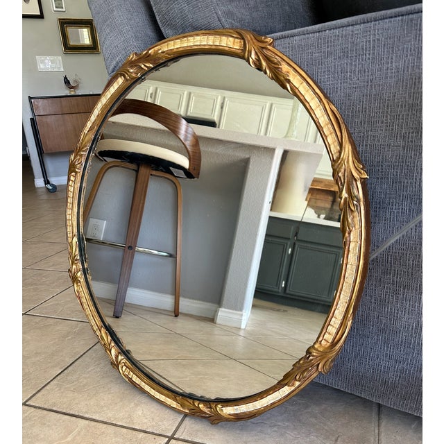 Round antique 1930s French Rococo style gold giltwood wall mirror featuring leafy scroll carvings.