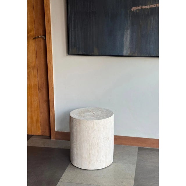 A beautifully understated sculptural side table crafted from solid teak wood, defined by its clean cylindrical silhouette...