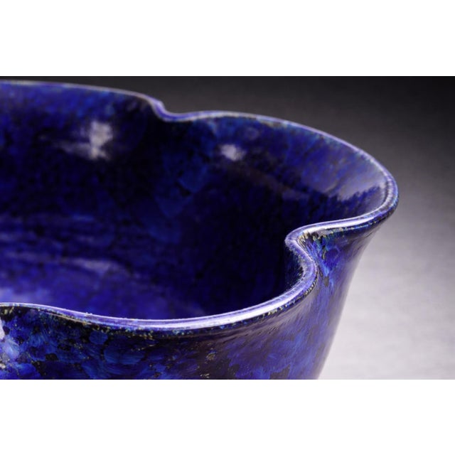 A richly glazed cobalt blue studio pottery bowl signed “Koski 2003,” featuring a striking crystalline bloom glaze and...