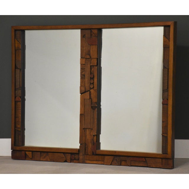 A mid century modern brutalist mirror. Made in USA. Circa 1970’s. Excellent condition. 55” wide. 2” deep. 40.5” tall.