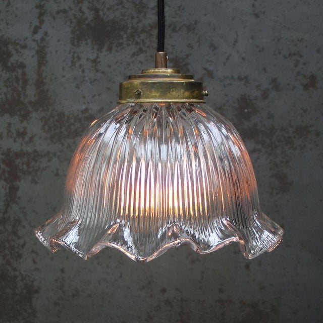 Clear glass lampshade by Holophane, France. Brass glass holder with porcelain bulb holder. 2 meter black wire. This piece...