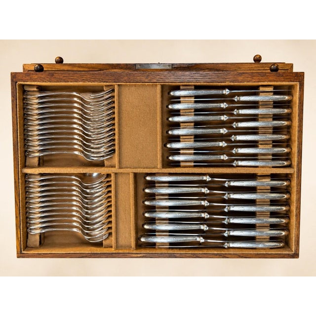A complete 132-piece flatware set by christofle, "ribbons" pattern, presented in its original solid oak case with four...