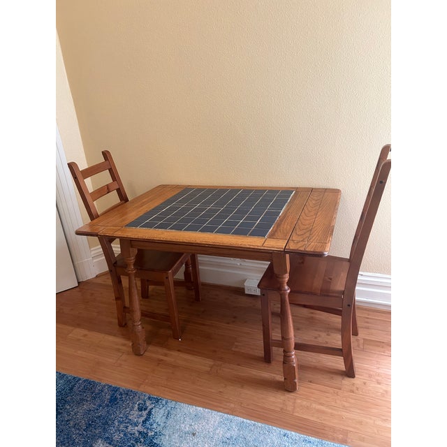 This is an early to mid 20th century tile top dining table. Oak wood and ceramic blue grouted tiles. Bought at a funky...