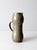This vintage handmade studio pottery pitcher features a soft moss green glaze layered over a warm clay base, creating...