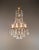 This antique French chandelier captivates with its sleek, tiered design featuring curved brass arms and a varied...