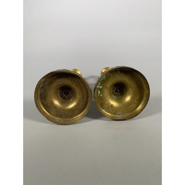A pair of Louis XVI period candlesticks in marble and chased and gilded bronze. They rest on a circular base adorned with...