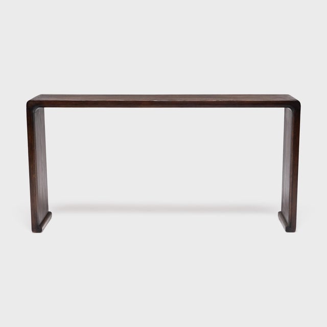With no stretchers or spandrels, this slender console table flows as one continuous ribbon, rounding the bend with simple...