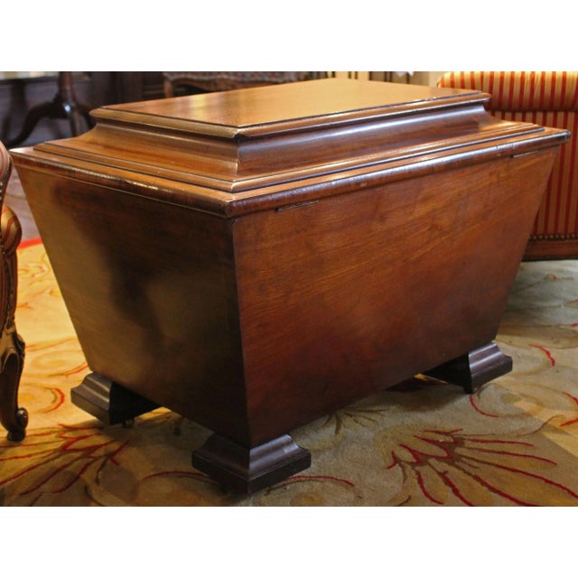 George IV period cellarette of mahogany with carved laurel wreath. Well molded and shaped top and feet. Bramah lock. Ideal...