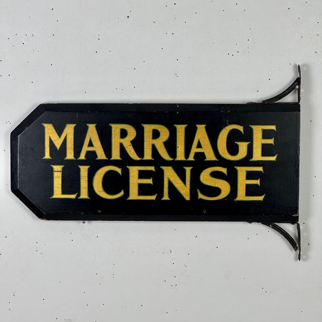 A lovely directional marriage license sign. It's a nice substantial thick piece of wood that's trimmed on its left sides'...