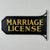 A lovely directional marriage license sign. It's a nice substantial thick piece of wood that's trimmed on its left sides'...
