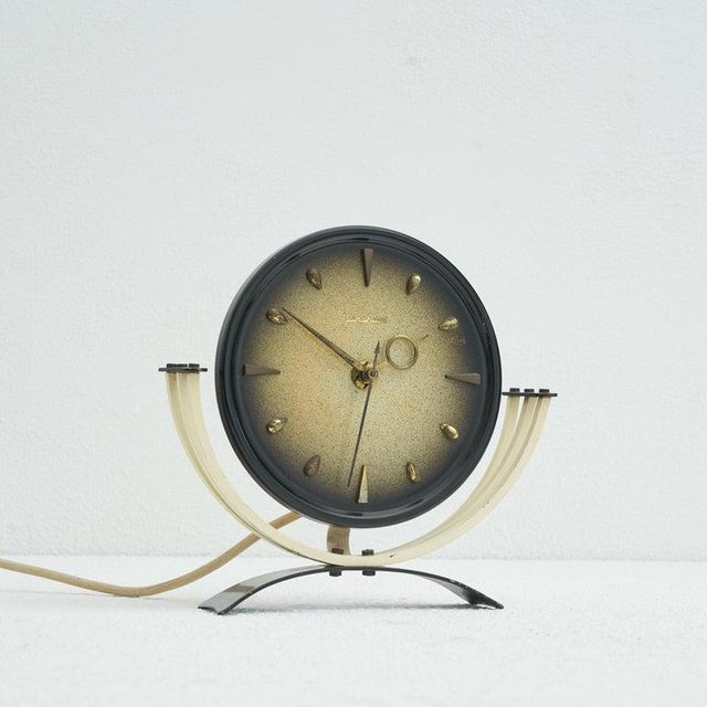 Junghans mid-century table clock in metal and brass. Germany, 1950s Decorative and elegant mid century table clock made by...