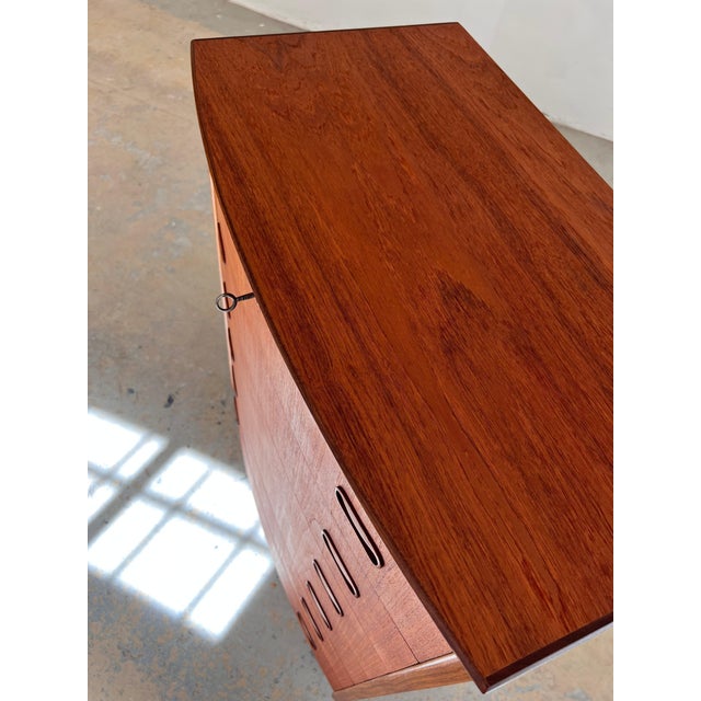This Danish teak chest of drawers is an exceptional collector's item, instantly recognizable by its rare, semi-circular...