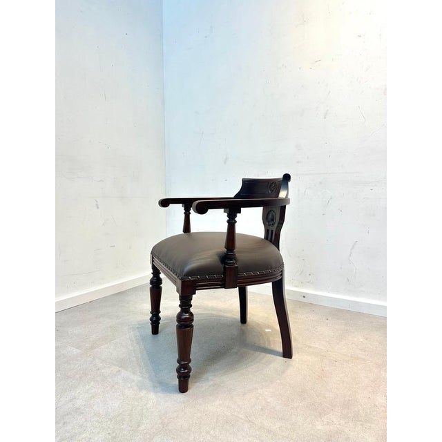 An elegant classic desk chair in solid mahogany, featuring fine hand-carved details and a timeless design. The curved...