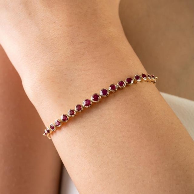 This timeless contemporary tennis bracelet features 17 round cut rubies totaling 1.16 carats, set in 18k yellow gold. Each...