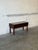 This console features a rectangular silhouette elevated by straight legs. The striking top showcases a geometric tile...