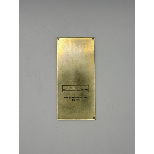 Authentic 2010 Pebble Beach Concours d’Elegance dash plaque in brass, featuring an Art Deco–inspired automotive motif....