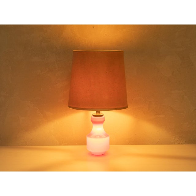 Classic table lamp from the 1970s. High-quality base made of solid-colored glass in red and a lampshade in beige. Quality...