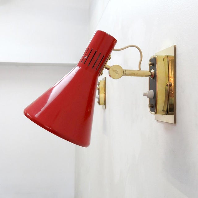Wonderful pair of articulate Italian wall lights Model 2085 by Bruno Gatta, manufactured by Stilnovo, 1950s, with red...