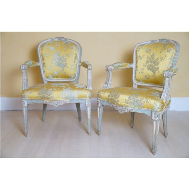 A refined pair of Louis XVI–style painted fauteuils, featuring elegant neoclassical lines and beautifully carved details...