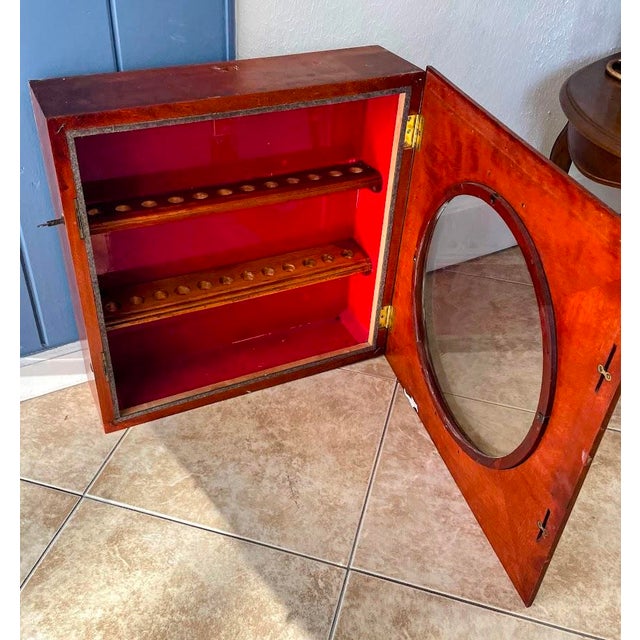 This striking antique wall cabinet began its life as a traditional oak clock case, crafted in the early 20th century....