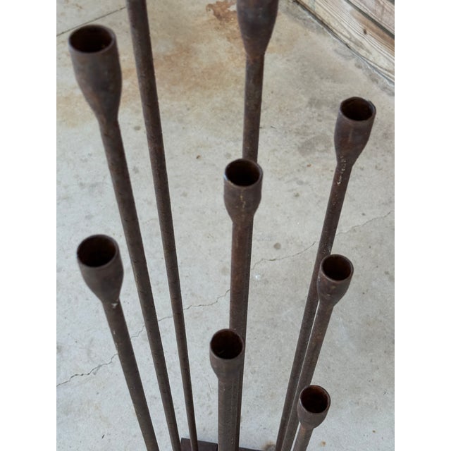 Sculptural and striking, this Mid-20th Century forged iron candle holder features nine tapered rods of varying heights...