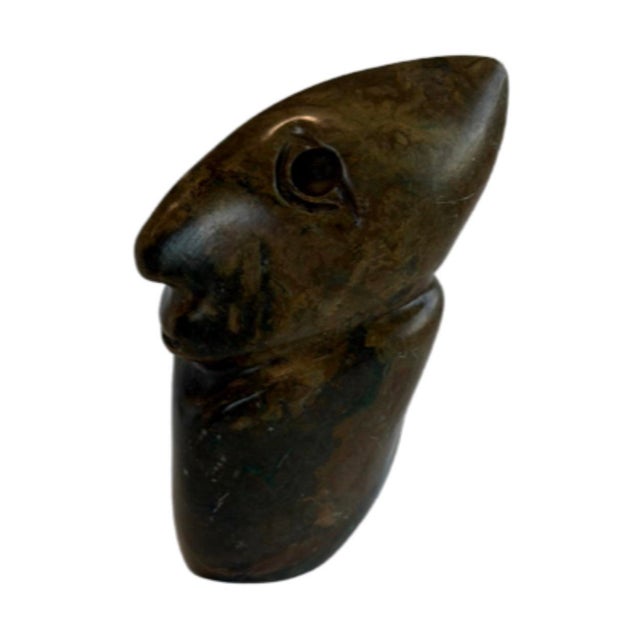 A striking vintage hand-carved stone sculpture featuring an abstract stylized human figure. The compact sculpture is...