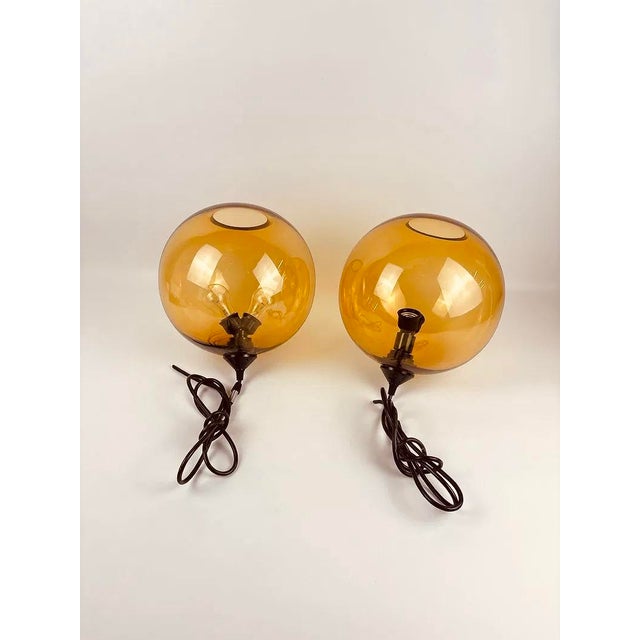 A gorgeous pair of vintage Mid Century Modern Style Pendant Lights in Amber Smoked Glass. When lit they cast the most...