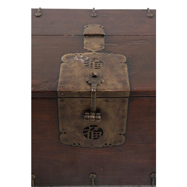 Old Chinese chest in wood with hinges. Decorative plates and bronze lock, 20th century. Very good conditions.