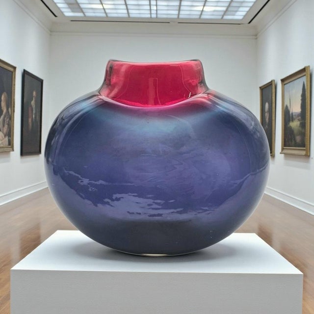 A signed studio-glass vase by Australian artist Maureen Williams, distinguished by a flattened “moon” silhouette and a...