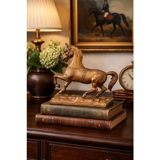 This vintage cast metal horse sculpture features a dynamic prancing stance, beautifully modeled with strong musculature,...