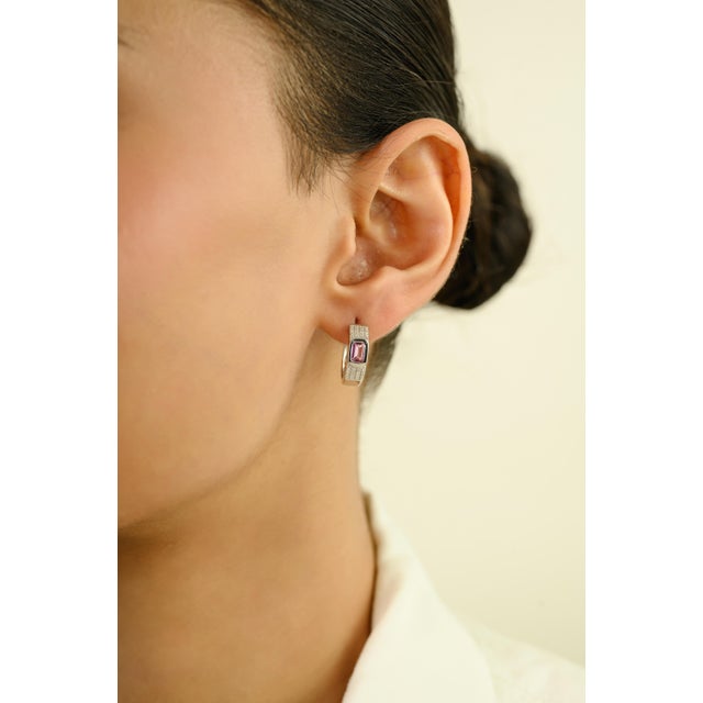 These elegant huggie hoop earrings feature 2 octagon-cut pink sapphires totaling 0.73 carats, set in rich 14k White gold....