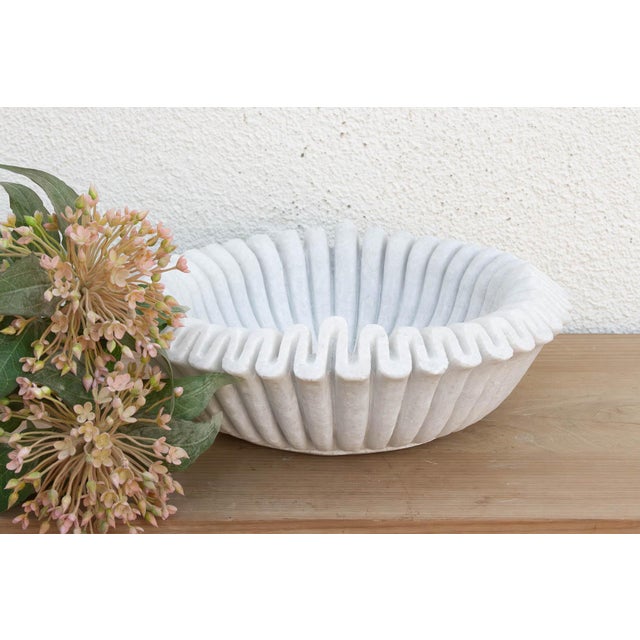 Carved from a single block of pristine white marble, the vessel has been meticulously hand-chiseled to create a continuous...