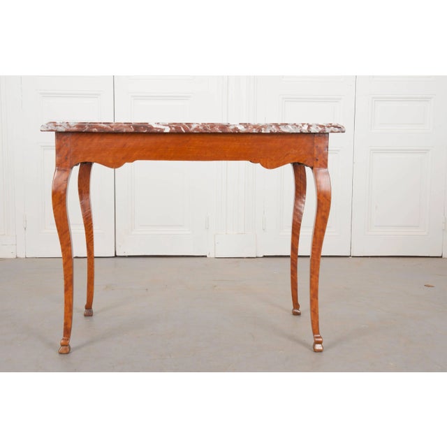A breathtaking birch writing table, made in France (circa 1810). On top, the Languedoc red marble is a rich oxblood color...