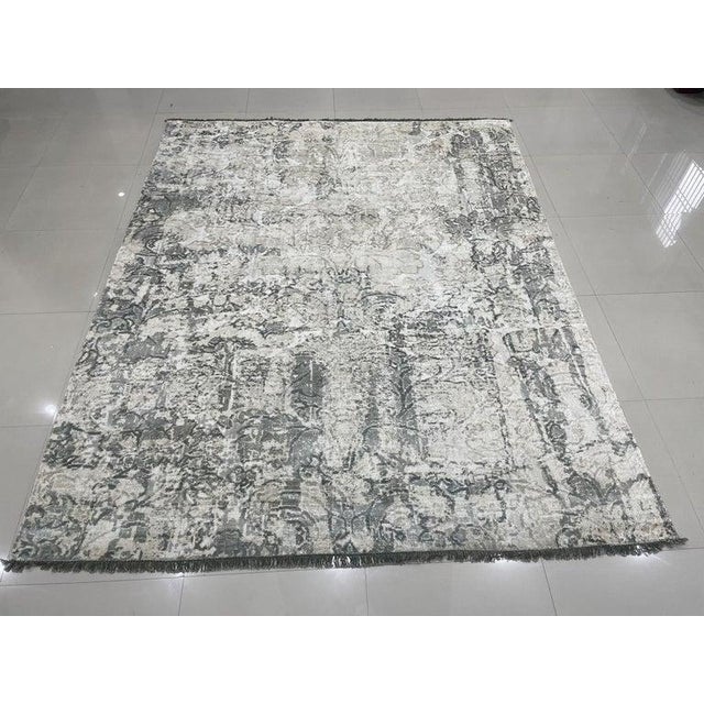 This hand knotted pile rug features a primary color palette of ivory, beige, cream, and white. Crafted from high-quality...