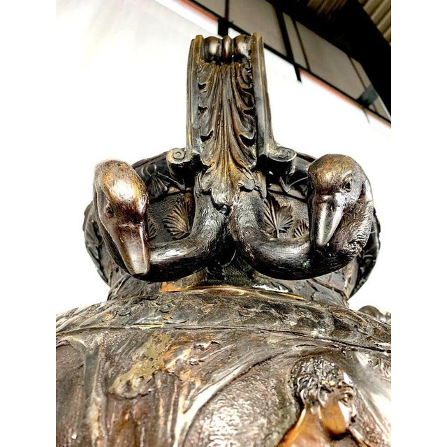 Cast bronze with a dark patination, the neo classical greek style urns with of typical form with handles and relief in the...
