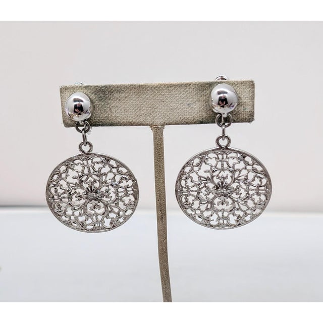 Circa 1973 rhodium plated round domed top with round flat openwork drop clip and adjustable screw back earrings. Marked...