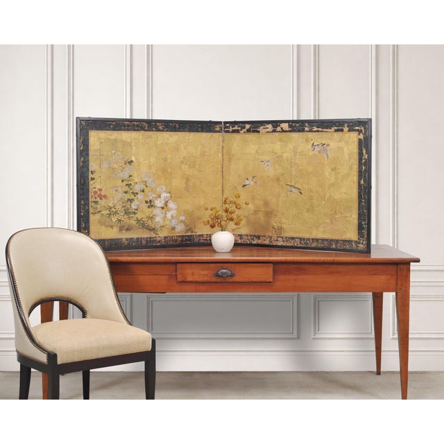 A charming weathered Japanese two-panel Edo period folding gilt byobu screen depicting four birds amid flowering...