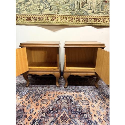 Pair of Louis XVI style French bedside lockers crafted in oak. Classic elegant design with cabriole legs and decorative...