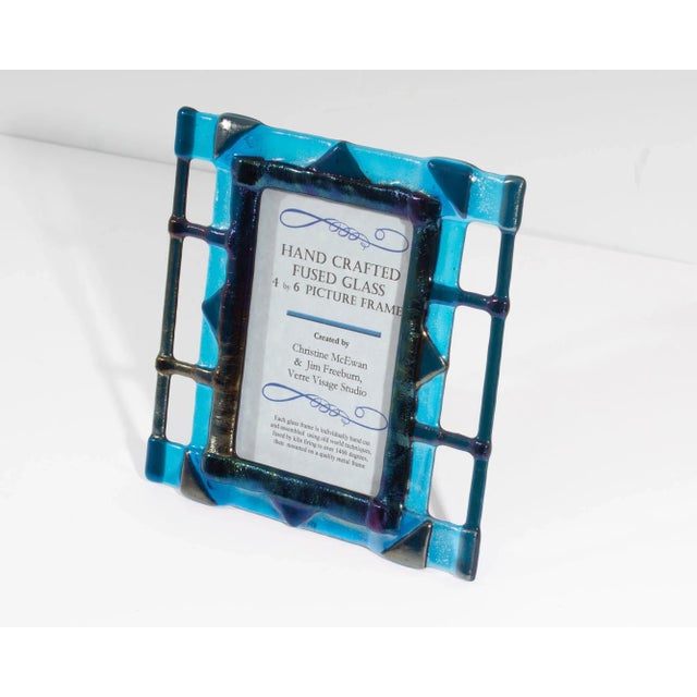 A fused glass picture frame created by Christine McEwan and Jim Freeburn of Verre Visage Studio. This frame features black...