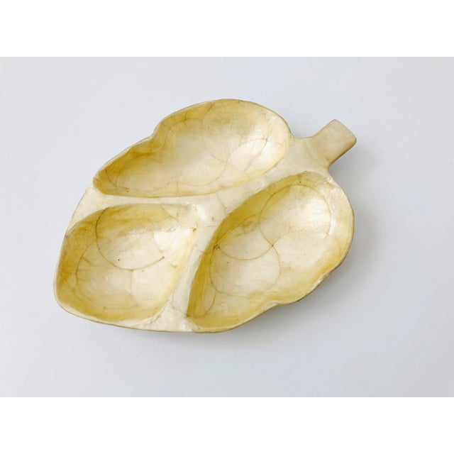 A vintage divided leaf shaped tray made out of capiz shell. Perfect for using as a jewelry dish or desk organizer.