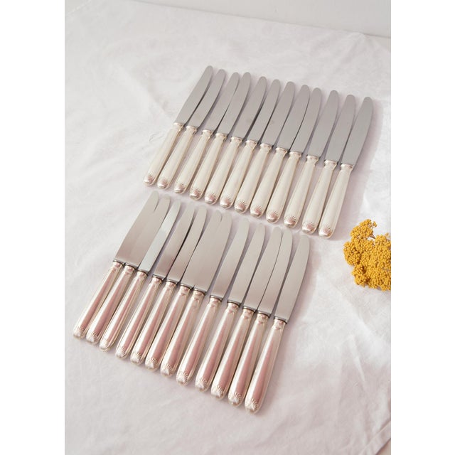 Set of 24 French knives, including 12 table knives and 12 starter knives, with silver-plated metal handles decorated in...