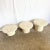 A sculptural set of three postmodern side tables, crafted with textured faux coquina surfaces that mimic natural coral...