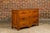 A French walnut commode from the 18th century with three drawers, carved apron and ornate hardware. This 18th-century...