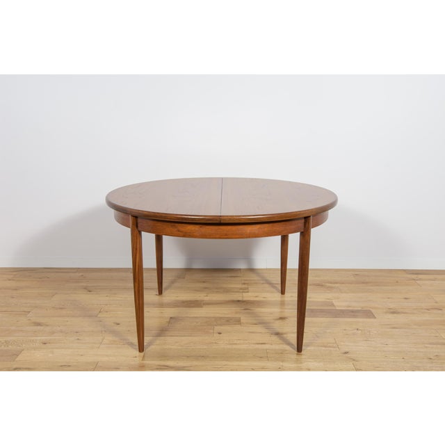 This round extendable dining table was produced by G-Plan in the 1960s. The table has profiled reinforced edges of the...