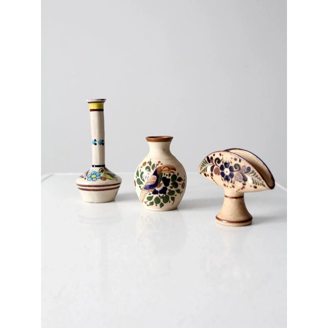 This charming collection includes three vintage Tonala pottery pieces: two vases and a napkin holder. Each piece is hand-...