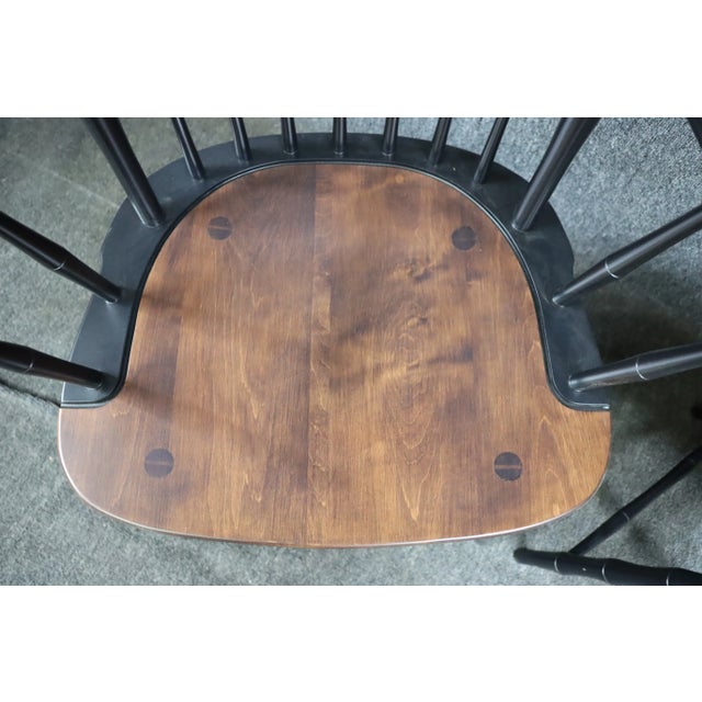 A pair of bench-made armchairs in black lacquer bamboo style frames with Cherry seats.