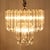 - 40 triangular thick lucite dangles hang from a brass, 2 tiered structure. - 6 chandelier base light sockets - Corded...