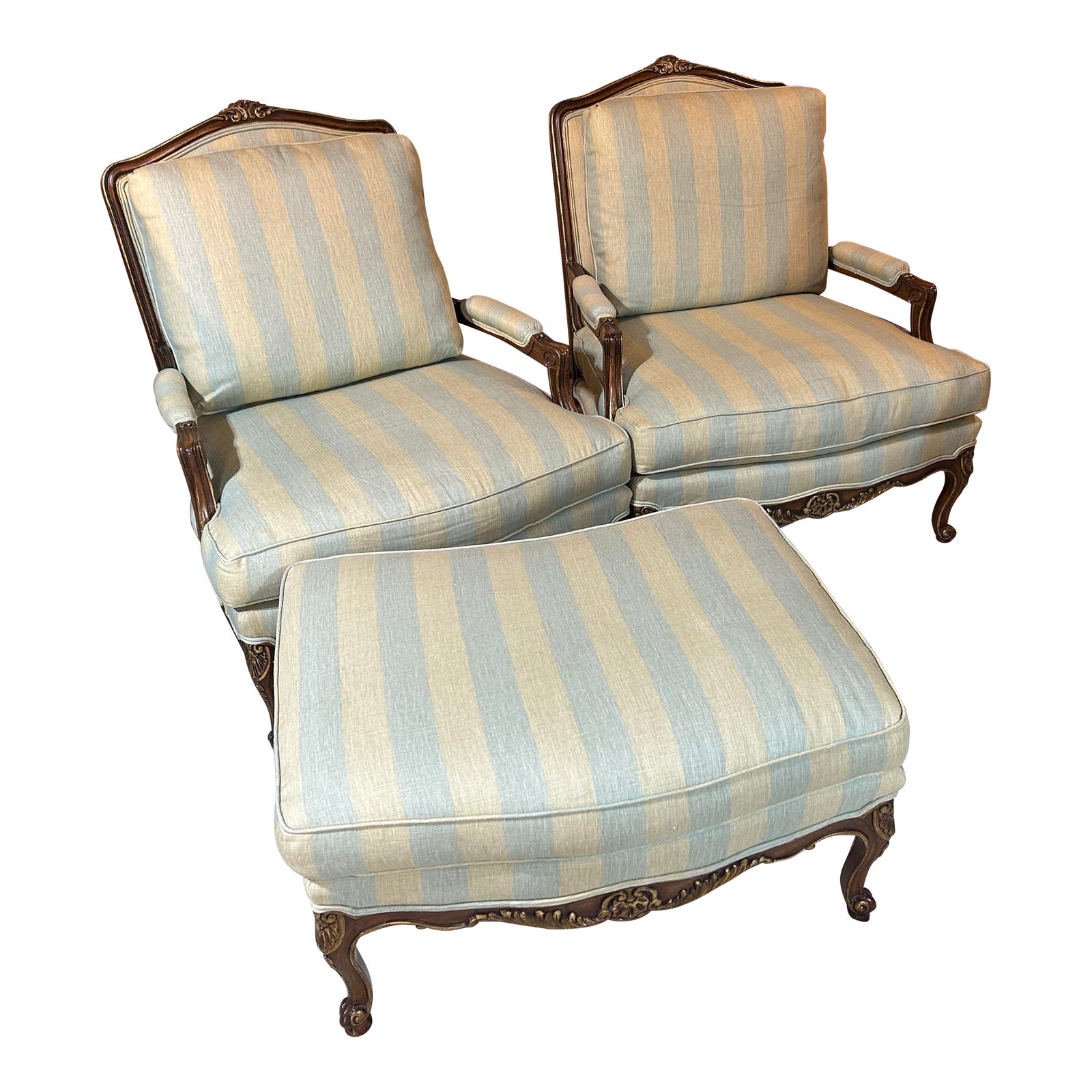 Two striped upholstered armchairs with matching ottomans.