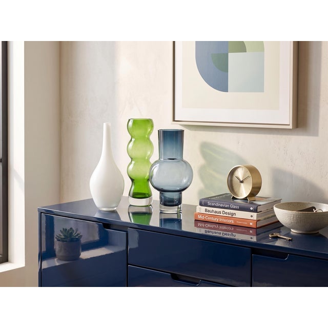 A striking, pre-curated trio of modernist glass vessels playing with scale, opacity, and architectural rhythm. Anchored by...